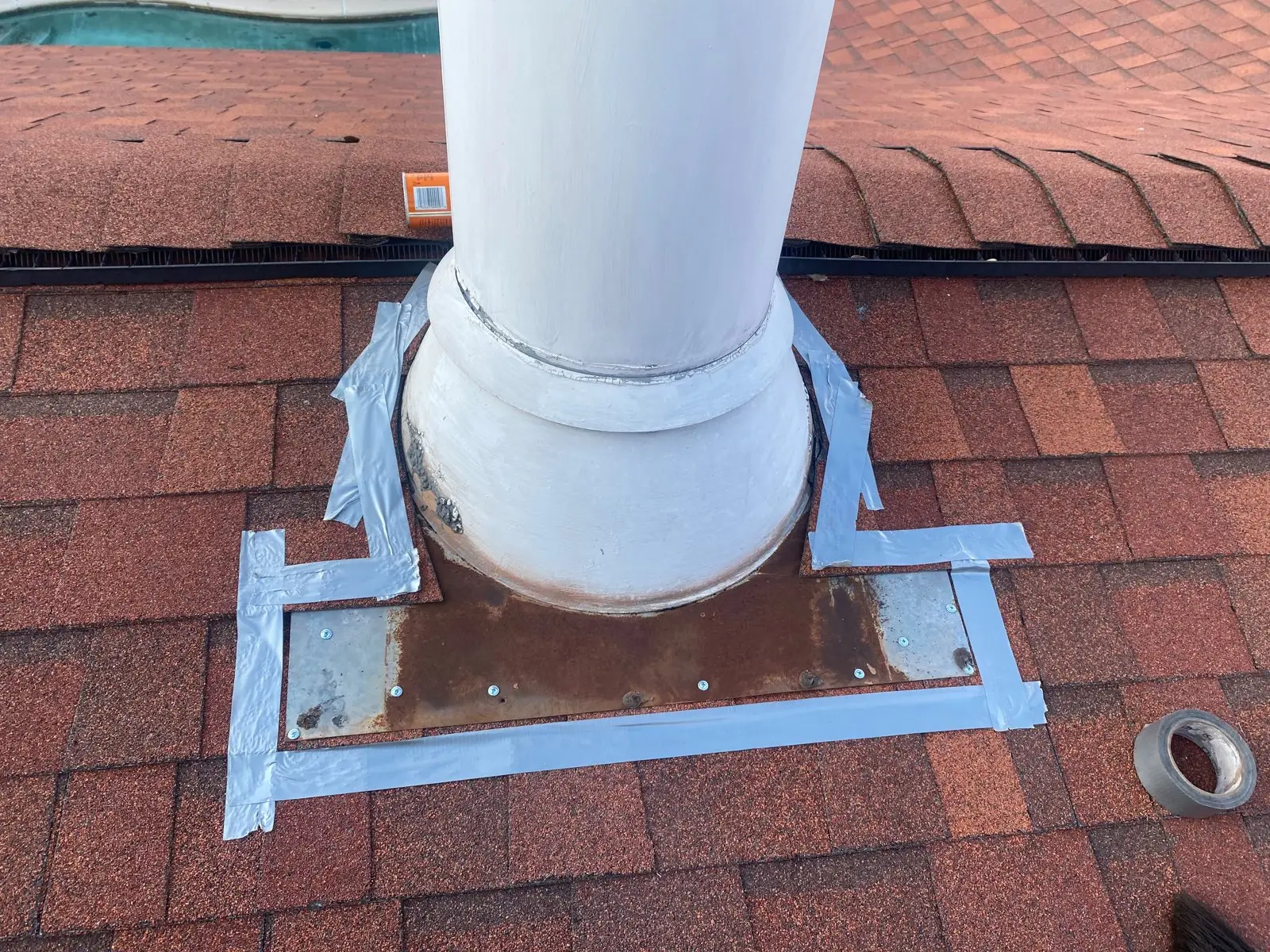 Chimney flashing sealed against a shingle roof to stop a leak