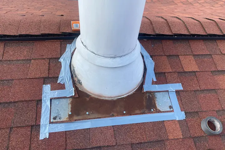 Chimney flashing sealed against a shingle roof to stop a leak