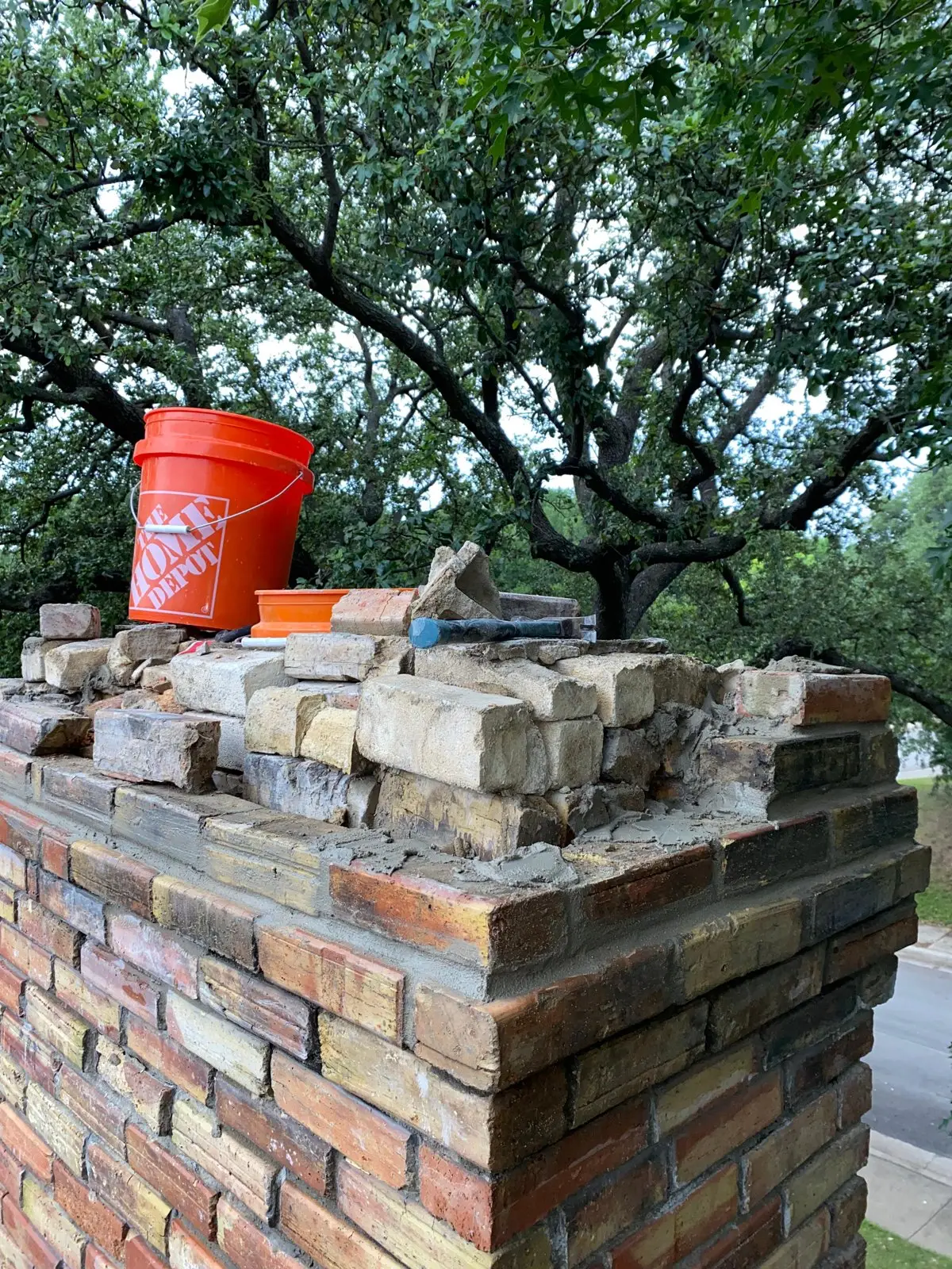 Chimney masonry repair with brick and mortar work in progress in Dallas
