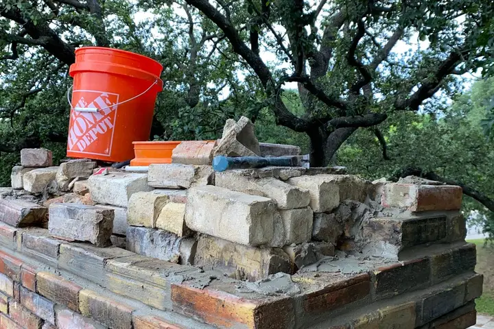 Chimney masonry repair with brick and mortar work in progress in Dallas
