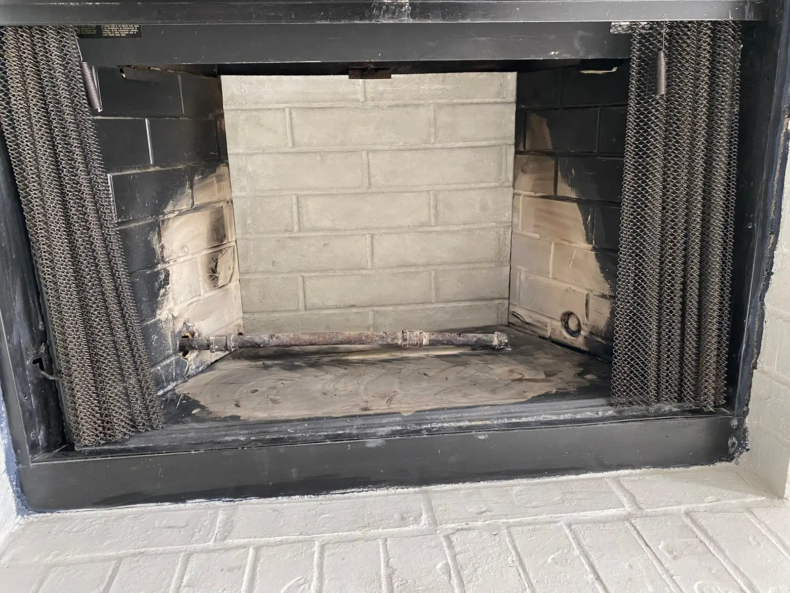 Soot-stained fireplace firebox before a fireplace cleaning in Dallas