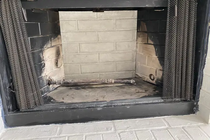 Soot-stained fireplace firebox before a fireplace cleaning in Dallas