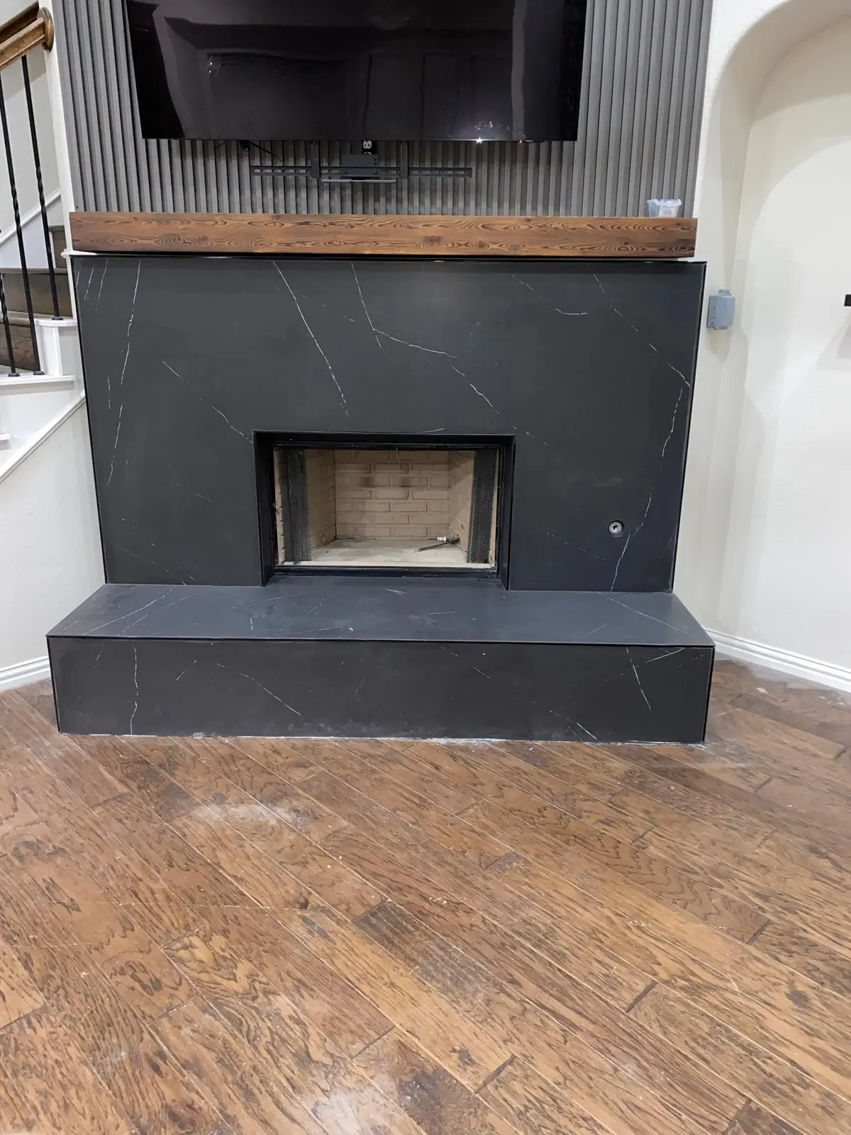Remodeled fireplace with a new dark stone surround in a Dallas home