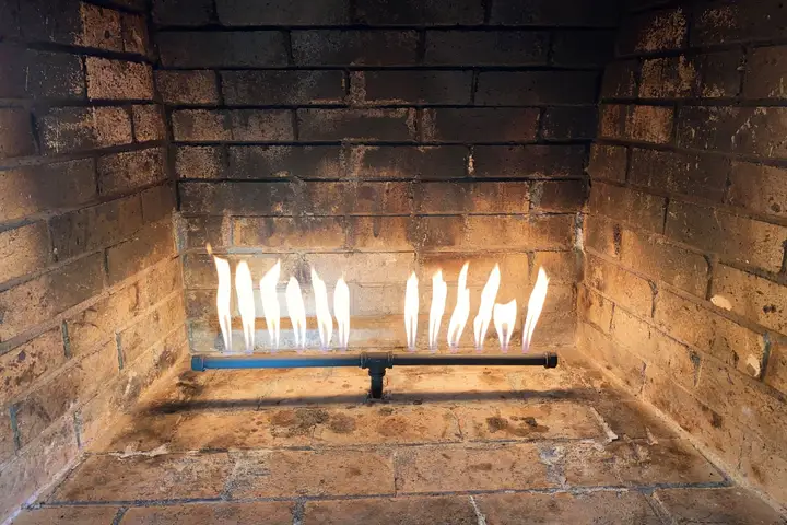 Gas fireplace burner lit during a repair test in a Dallas home