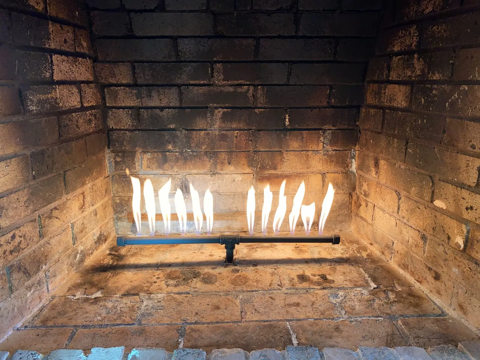 Gas fireplace burner lit during a repair test in a Dallas home