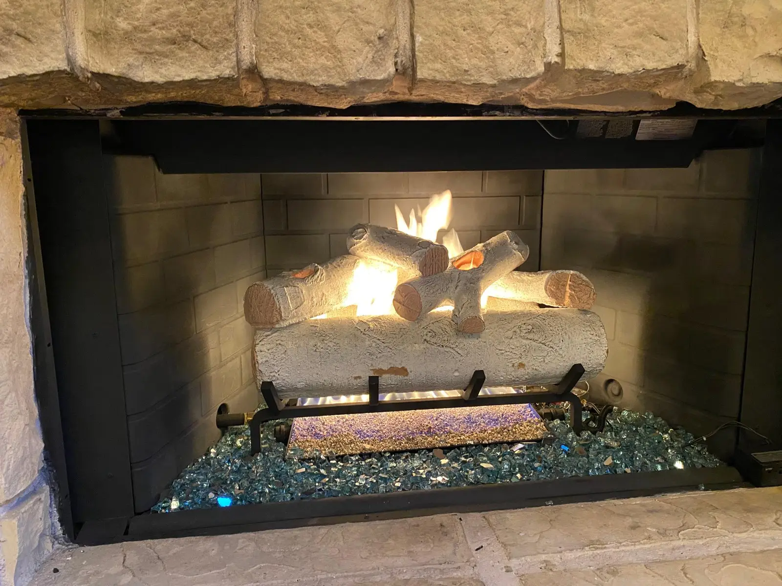 Gas log set installed and burning in a Dallas fireplace